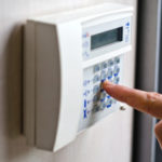 Finger pressing keys on alarm keypad