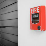 color fire alarm switch on black and white wall