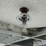 Installation process of a fire sprinkler in a ceiling - always ready for spraying water on a fire. Useful file for your brochure about security, safety and water piping systems.